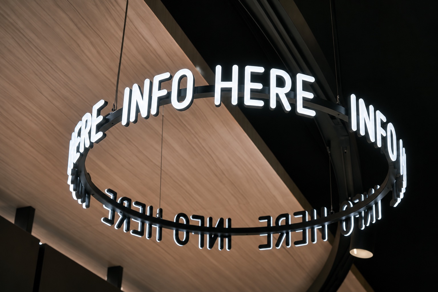 Custom illuminated letters suspended around a circular metal frame.
